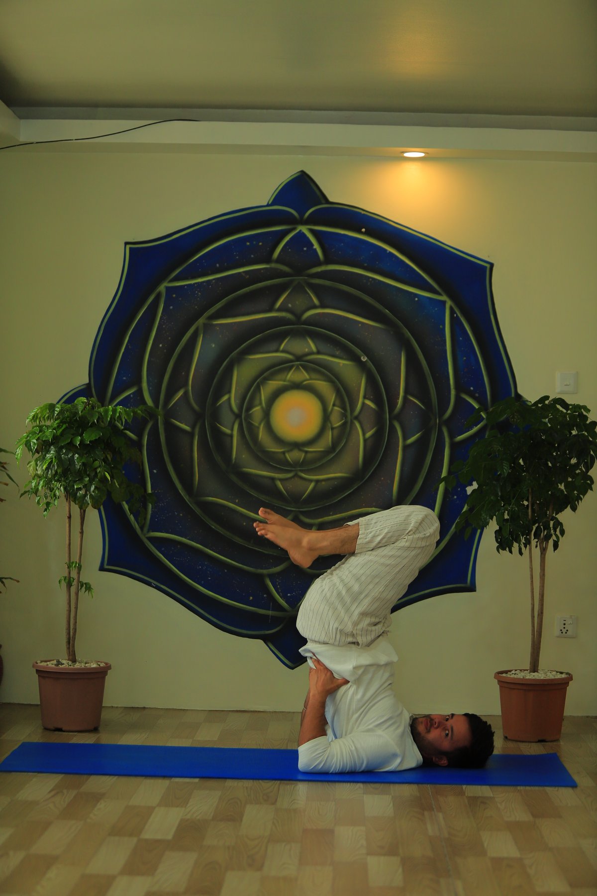 Headstand by the mandala wall
